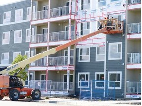 A worker works on the exterior of a multiple-unit residential building in Harbour Landing in Regina on Wednesday. The 75-unit project on 5500 Mitchinson Way by Porchlight Developments has a permit value of $8.8 million. 
 TROY FLEECE/Regina Leader-Post