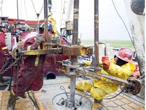 Workers on the floor of a drilling rig in the Bakken formation near Weyburn, Mining and oil and gas workers took an eight per cent hit to their average weekly earnings in May.  File photos by Troy Fleece.