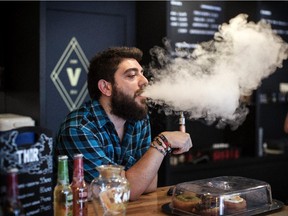 Vape Lab employee Leonardo Verzaro uses an E-Cigarette while working on August 27, 2014 in London, England.