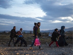 Migrants and refugees cross the Greece-Macedonia border, near Gevgelija, on November 24, 2015.