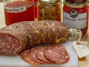 A selection of fermented products from Salt Boutique including clockwise left to right, strawberry pepper shrub, sour dough starter, kimchi, Saskatoon berry shrub, fermented radish, and soppressata.