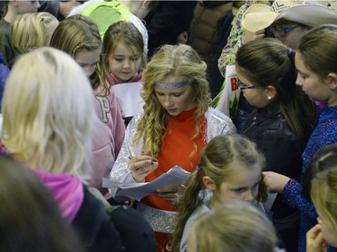 Cashlyn Krecklau, a rider with Calamity Cowgirls, signs autographs at Agribition at the Brandt Centre in Regina, Sask. on Saturday Nov. 28, 2015. (Michael Bell/Regina Leader-Post)