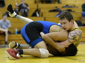 Conner McLachlan, right, wrestles Charles Cook, left, during the Cougar Invitational wrestling tournament on Saturday.