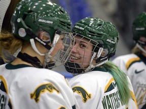 Nikki Watters-Matthes, right, laughs with University of Regina Cougars teammate Emma Waldenberger after the second period of Saturday's Canada West women's hockey game against the Lethbridge Pronghorns.