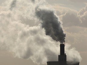 Exhaust rises from the main chimneys of a coal-fired power plant.