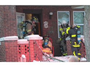 Firefighters prepare to enter an apartment in which careless cooking was blamed for a blaze.