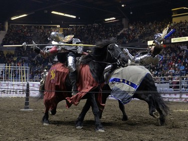Josh Tobey, right, a member of the Knights of Valour Jousting Troupe, falls from his horse at Agribition at the Brandt Centre in Regina, Sask. on Saturday Nov. 28, 2015.
