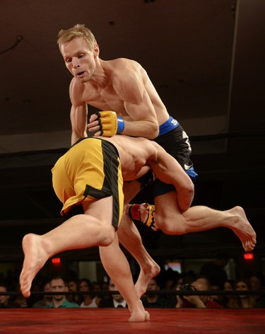 Matt Fedler, bottom, goes low on Jesse Boldt, top, during their MMA fight at Saturday Night Fights held at the Conexus Arts Centre in Regina, Sask. on Saturday Nov. 14, 2015.