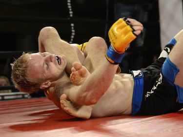 Matt Fedler, far side, beats Jesse Boldt, near, with a submission hold during their MMA fight at Saturday Night Fights held at the Conexus Arts Centre in Regina, Sask. on Saturday Nov. 14, 2015.