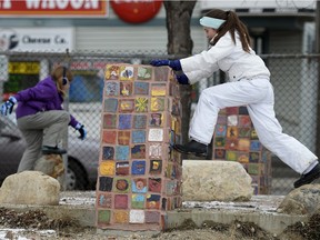 Maya Marsden-Beck, left, and Zoe Martin, right, play on rocks and a monument during a Connaught School Rally held at the new school's future site in Regina, Sask. on Saturday Nov. 21, 2015. The rally's intent was to draw attention to the lack of progress on the rebuilding of the school.