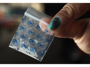 A crystal meth user holds a tenth of a gram of crystal meth.