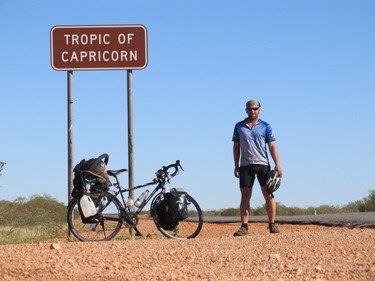 Mike Boles stands with his trusty bike at the Tropic of Capricorn in Western Australia.