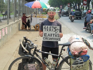 Mike Boles stands with his bike in Java, Indonesia, during an epic six-year cycling journey that took him around the world. At this point, he had officially cycled the circumference of the globe.