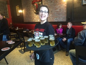 Magdalena Shenher, server at Rebellion Brewing, carries a tray of Lentil Cream Ale samples on Thursday afternoon at the beer's official launch. The local brewery partnered with AGT Foods to create the rare beer, made with King Red lentils.
