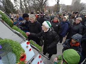 People place their poppies on the Cenotaph during a Remembrance Day ceremony in downtown Regina, Sask. on Wednesday Nov. 11, 2015. (Michael Bell/Regina Leader-Post)
