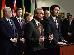Saskatchewan Premier Brad Wall (centre) speaks following the photo op during the first ministers meeting in Ottawa.