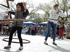 Nylah Phonsavatdy (left) and her mother Shaeya Baliko-Phonsavatdy (right) hoola-hoop at the first outdoor farmers' market of the year at City Square Plaza in Regina on May 2, 2015.