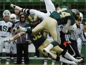 REGINA, SASK - Sept. 27, 2014  -  Saskatoon Huskies receiver Kit Hillis (#8) is brought down by Regina Rams linebacker Michael Stefanovic (#44) and runningback Blake Anaka (#33) during a game held at Mosaic Stadium in Regina on Saturday Sept. 27, 2014.