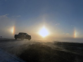 Sundogs are shown on the horizon and drifting snow as vehicle traffic makes its way west into Regina on the Trans-Canada Highway.