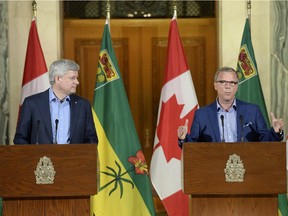 Former prime minister Stephen Harper, left, and Saskatchewan Premier Brad Wall holding a news conference in Regina in July.
