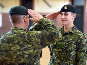 Lieutenant Colonel Victor Sattler (L) salutes  graduate Jason Klink from DP 1 Basic Military Qualification Co-operative Education Program 0153 high school military training course in Regina June 11, 2015.