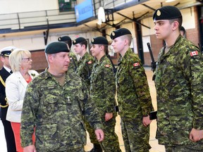 Lieutenant Colonel Victor Sattler (R) and Lt.-Gov. Vaughn Solomon inspect graduates from DP 1 Basic Military Qualification Co-operative Education Program 0153 high school military training course in Regina June 11, 2015. Sattler (L) talks with Pte Conner Wilder.