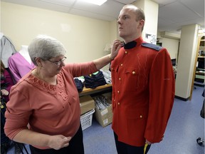 Tailor shop employee Marina Rosca sizes a red serge coat on cadet Kyle Doman at the RCMP tailor shop at Depot in November 2015.