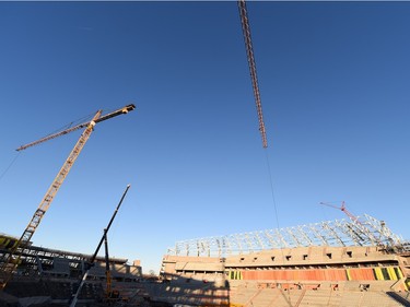 Crane operators work inside the stadium.
