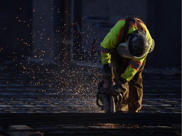 A construction worker cuts through rebar at the new Mosaic Stadium.