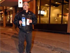 Kelly Malloy holds up his handicapped parking permit and a parking ticket he received on Cornwall Street near 11th Ave. in Regina.