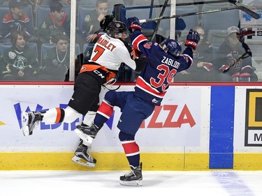 Medicine Hat Tigers' Matthew Bradley, left, and Regina Pats' Lane Zablocki collide during first period WHL action at the Brandt Centre  in Regina on Tuesday.