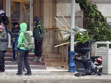 A young lad travelling with a group of kids slips and falls during nasty winds in front of the Hotel Saskatchewan in Regina, SK on November 18, 2015.
