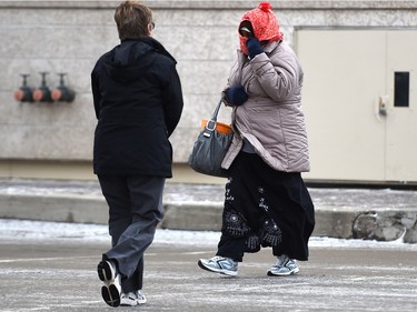 Pedestrians deal with strong winds in downtown Regina on Wednesday.