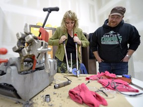 Loreena Spilsted, left, chair of Skills Canada Saskatchewan, tries her hand at pipe bending as Brandon Fual, instructor with UA local 179 plumbers and pipe fitters, looks on during Try-a-Trade at Regina Trades and Skills Centre in Regina on Nov. 3, 2015.