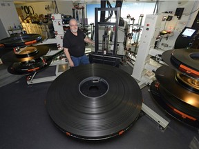 Trevor Ewen, chief projectionist at the Kramer Imax Theatre, poses with a film reel -- which will be similar to the new Star Wars movie --which is approximately 56,000 feet long, weighs 800 pounds, contains almost 250,000 individual frames and is worth around $50,000.  The Kramer Imax theatre in Canada that will be showing Star Wars: The Force Awakens on film rather than digital.