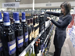 Doneane Papandreos of Willow Park Wines and Spirits stocking shelves in the store.