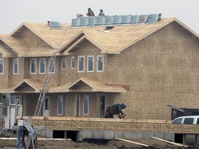Construction workers building homes at Green Alder Way in the city's south east. Housing starts were down nearly 70 per cent in October, according to CMHC.