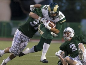 Atlee Simon of the University of Regina Rams powers into the tackling of Dane Bishop and Chris Friesen of the University of Saskatchewan Huskies during CIS action at Griffiths Stadium, Friday, September 18, 2015.