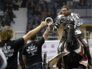 Shane Adams, a member of the Knights of Valour Jousting Troupe, hooks rings with a spear during the gauntlet at Agribition at the Brandt Centre in Regina, Sask. on Saturday Nov. 28, 2015.