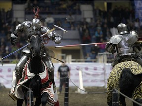 Shane Adams, left, captain and founder of the Knights of Valour Jousting Troupe, breaks a lance at Agribition at the Brandt Centre on Saturday.