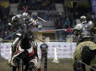 Shane Adams, left, a member of the Knights of Valour Jousting Troupe, breaks a lance at Agribition at the Brandt Centre in Regina, Sask. on Saturday Nov. 28, 2015.