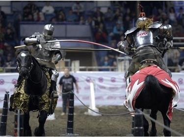 Shane Adams, right, a member of the Knights of Valour Jousting Troupe, is hit in the groin by a lance at Agribition at the Brandt Centre in Regina, Sask. on Saturday Nov. 28, 2015.