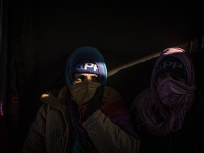 A Syrian refugee woman is seen within a tent at the railway station of Sid, Serbia, where Serbian authorities load trains with refugees to Croatia, Friday, Nov. 6, 2015