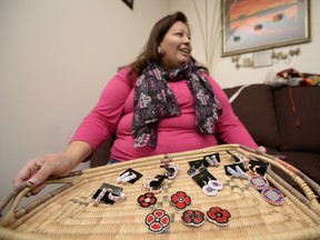 Vanea Cyr holds a basket that shows some of her bead work, including poppies, at her home in Regina on Saturday Nov. 7, 2015.