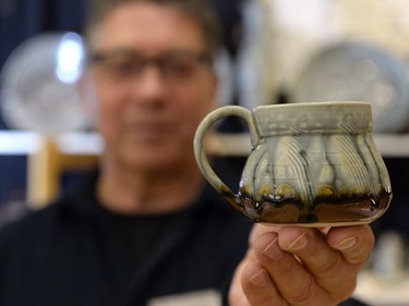 Zach Dietrich of Parsons Dietrich Pottery displays a coffee mug at Wintergreen Fine Craft Market in Regina, Sask. on Saturday Nov. 21, 2015. The annual event is organized by the Saskatchewan Crafts Council, which celebrates its 40th anniversary this year.