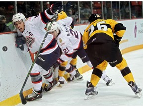 Regina Pats captain Colby Williams follows the puck around the boards past Linden McCorrister of the Brandon Wheat Kings during WHL action at Westman Place in Brandon on Sunday afternoon.