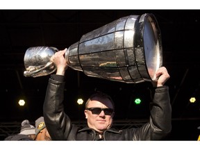 The Saskatchewan Roughriders are in hot pursuit of Edmonton Eskimos head coach Chris Jones, shown hoisting the Grey Cup that he helped the team win on Sunday.