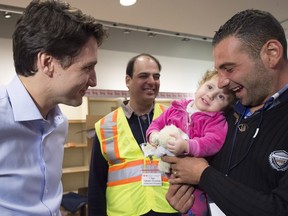 Prime Minister Justin Trudeau welcomes refugees fleeing the Syrian civil war, at Pearson International airport on Dec. 11.