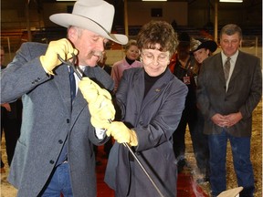 Neil and Marilyn Jahnke of Gouldtown, Sask. burn the brand at Agribition in 2002. Neil Jahnke was posthumously awarded the Chris Sutter Award by the CWA.