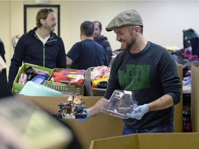 Niall O'Hanlon laughs while helping to sort donations intended for Regina-bound Syrian refugees on Dec. 12, 2015.